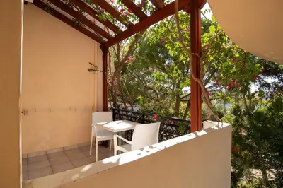 a patio with a table and chairs on a balcony at Virginia Studios in Palaiochóra