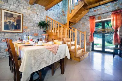 a dining room with a table and a stone wall at Charming Villa in Gerani Chanion