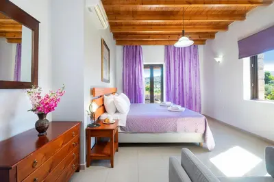 a bedroom with a bed with purple curtains at Charming Villa in Gerani Chanion