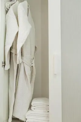 a closet with white towels hanging on a wall at Anastasia’s House in Kissamos