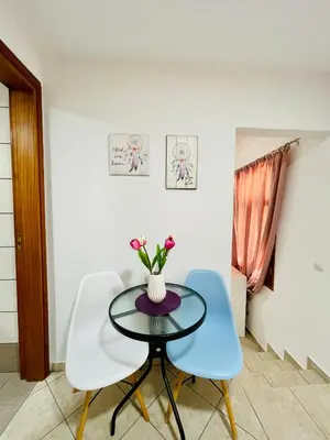 a table with two chairs and a vase with flowers on it at Anastasia’s House in Kissamos