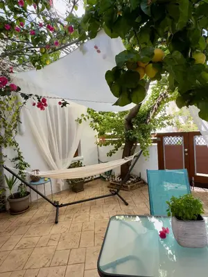 a patio with a table and chairs and a tree at Anastasia’s House in Kissamos