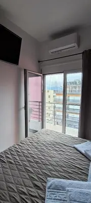 a bedroom with a large bed with a large window at Rafaellas Apartment in Chania Town