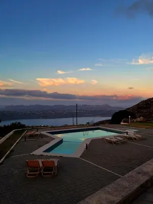 a swimming pool with chairs and a view of the water at Panos Village in Maláxa