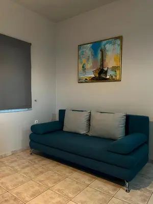 a blue couch in a room with a painting at Panos Village in Maláxa