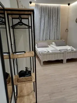 a room with two beds and a mirror and a bed at Romeos Studios in Agia Marina Nea Kydonias