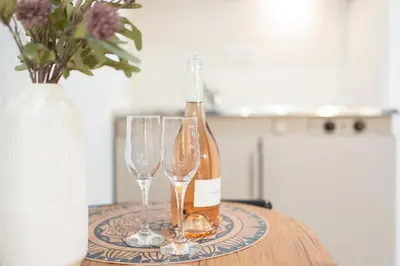 a bottle of wine and two wine glasses on a table at Romeos Studios in Agia Marina Nea Kydonias