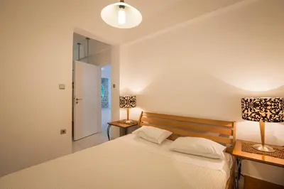 a bedroom with a bed and two lamps on two tables at Villa Asteri in Kalamaki Chanion