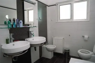 a bathroom with two sinks and a toilet at Villa Asteri in Kalamaki Chanion