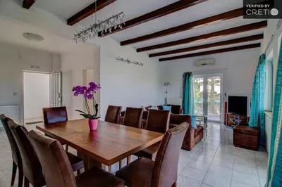 a dining room with a wooden table and chairs at Villa Asteri in Kalamaki Chanion