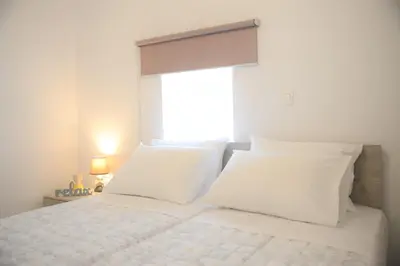 a white bed with white pillows and a window at Iconic Chania in Chania Town