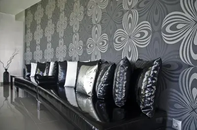 a black couch with pillows on a wall at Reveli Estate in Kalathas