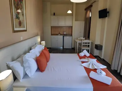 a bedroom with a large white bed with pillows at Creta Sun Studios in Kato Daratso