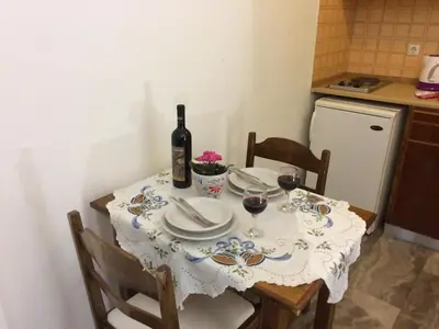 a table with a bottle of wine and two glasses at Creta Sun Studios in Kato Daratso