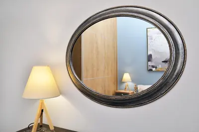 a large round mirror on a wall with a lamp at Alexandra's Garden Houses in Stalos