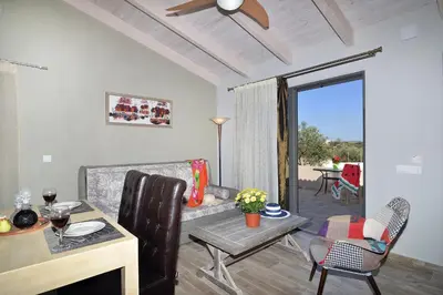 a living room with a couch and a table at Alexandra's Garden Houses in Stalos