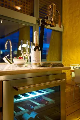 a bottle of wine sitting on top of a kitchen counter at Athina Epavlis - Ethereal Charm of Blue Horizons in Ravdhoúkha