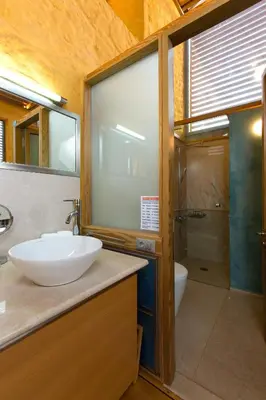 a bathroom with a sink and a glass shower at Athina Epavlis - Ethereal Charm of Blue Horizons in Ravdhoúkha