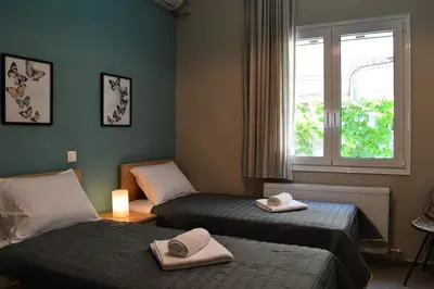 a hotel room with two beds and a window at casa Marilia in Chania Town