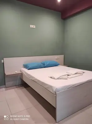 a bedroom with a large bed with white sheets at Homieland Souda in Souda