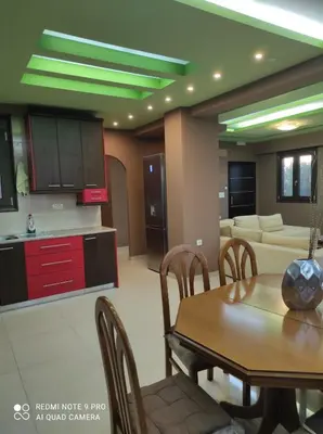 a kitchen and living room with a table and a couch at Homieland Souda in Souda