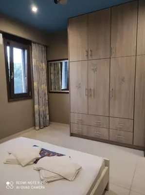 a bedroom with a bed and cabinets and a window at Homieland Souda in Souda
