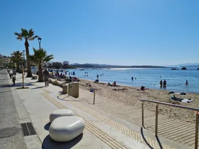 a beach with people on the sand and the water at Marika's Guest House Chania in Chania Town