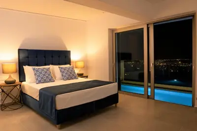a bedroom with a bed with a view of the city at NV Illusion in Chania Town