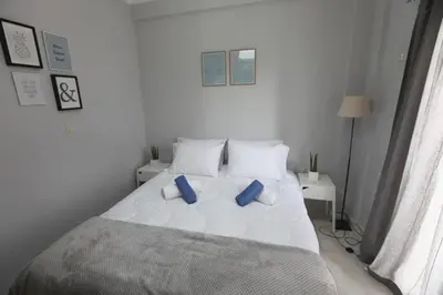 a bedroom with a white bed with blue pillows at Rita's home in Chania Town