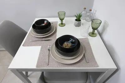 a white table with two bowls and plates on it at Rita's home in Chania Town
