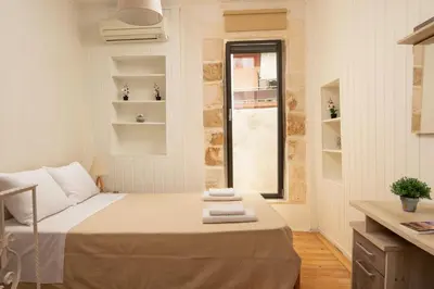 a small bedroom with a bed and a window at Evans House II One Bedroom Maisonette in Chania Town