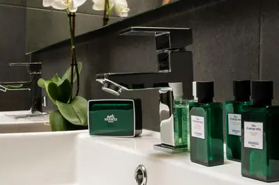 a bathroom sink with green bottles of soap and a faucet at NV Two in Chania Town