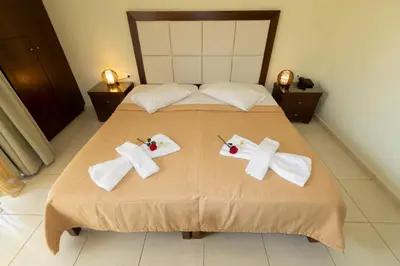 a bed with white towels and bows on it at Sandy Suites in Kalamaki Chanion