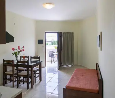 a dining room and living room with a table and chairs at Sandy Suites in Kalamaki Chanion