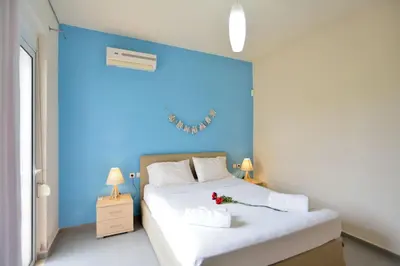 a bedroom with a blue wall and a bed at Villa Nopigia Mare in Kissamos