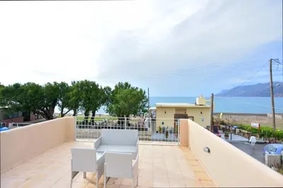 a balcony with a table and chairs and a view of the ocean at Villa Nopigia Mare in Kissamos