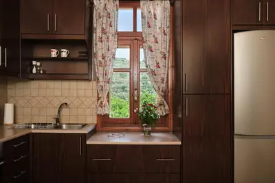 a kitchen with a window and a sink and a refrigerator at Batilas Garden House in Kissamos