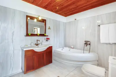 a bathroom with a tub and a sink and a toilet at Traditional Home Vereniki With Heated Pool - BY APOKORONAS VILLAS in Gavalochori