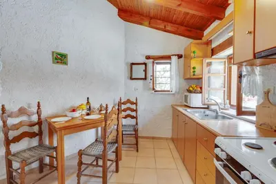 a kitchen with a table and chairs and a sink at Traditional Home Vereniki With Heated Pool - BY APOKORONAS VILLAS in Gavalochori