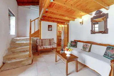 a living room with a staircase and a couch at Traditional Home Vereniki With Heated Pool - BY APOKORONAS VILLAS in Gavalochori