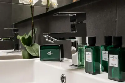 a bathroom sink with green bottles ofodorizers and a sink at NV One in Chania Town