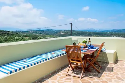 a table and chairs on a balcony with a bench at MaGea-Thalassa,Top floor Cretan studio with views in Tavronitis