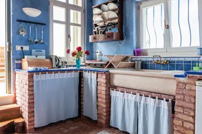a kitchen with blue walls and a sink and a counter at MaGea-Thalassa,Top floor Cretan studio with views in Tavronitis