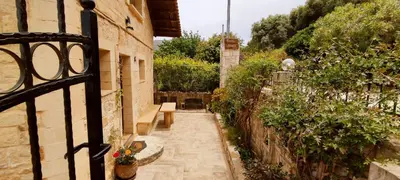 a gate to a garden with a bench and plants at Vasiliki's Residence - Breathtaking View in Kissamos