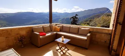 a couch on a balcony with a view of mountains at Vasiliki's Residence - Breathtaking View in Kissamos
