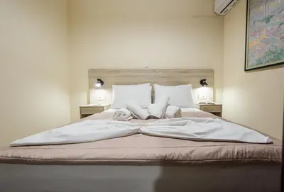 a large bed with white sheets and pillows on it at Mavros Molos Seaside Apartment in Kissamos