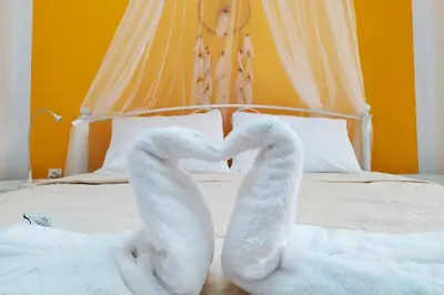 two swan towels are forming a heart on a bed at Sunday Apartment Chania 2A in Chania Town