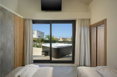 a bedroom with a large window with a bath tub at Sun Ray Beach Life Villa in Agia Marina Nea Kydonias