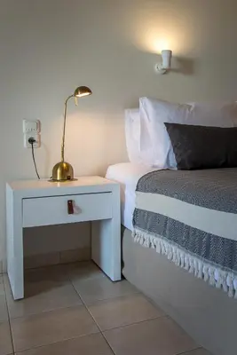 a bedroom with a bed and a nightstand with a lamp at Kanso Rooms in Galatás