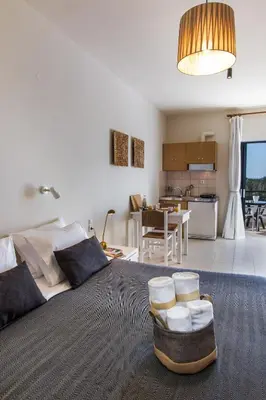 a living room and kitchen with a large bed at Kanso Rooms in Galatás